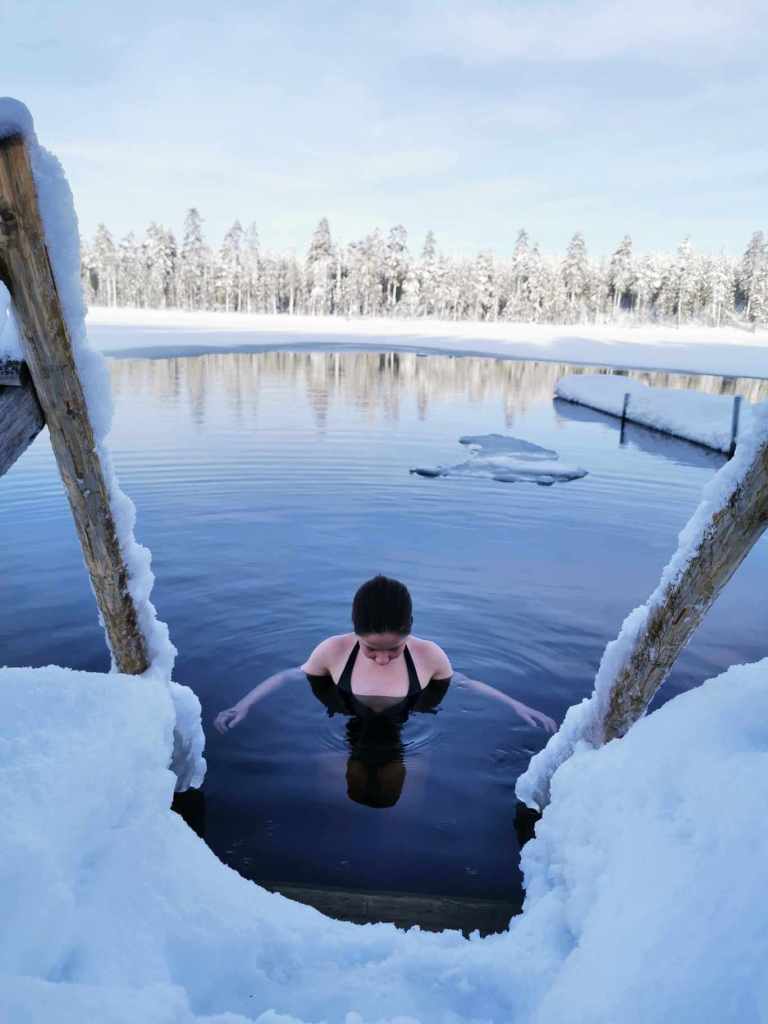A person swimming in an icy lake in Lapland